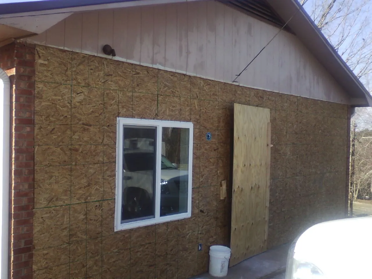 OSB sheathing on a garage addition wall before siding in Trail